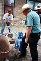 Pressing Earth Block by hand. Lever on a Cinva Ram at southwest solaradobe school